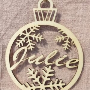 Boule de Noël Personnalisée en Bois Prénom "Julie" (Flocons) Ajoutez une touche unique à votre sapin avec cette magnifique boule de Noël en bois clair. Découpée au laser avec précision, elle arbore le prénom "Julie" (ou votre choix) au centre, entouré de délicats flocons de neige. Parfait pour un cadeau personnalisé mémorable ou une décoration de style rustique chic. Livrée avec sa cordelette en jute naturelle.